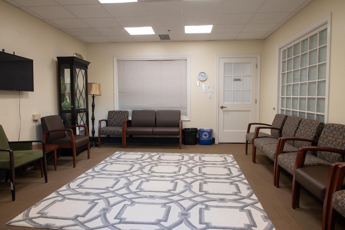 Group therapy room in Lindley Hall with several dark chairs and white and gray rug