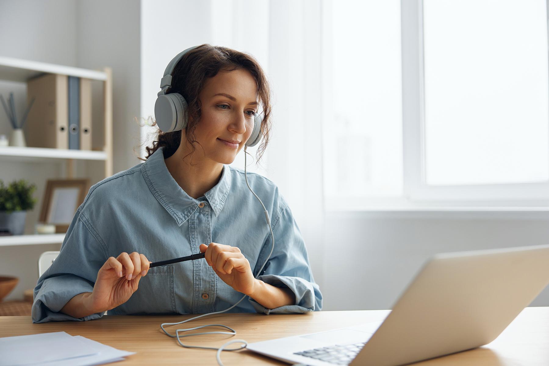 woman sitting at laptop with headphones on