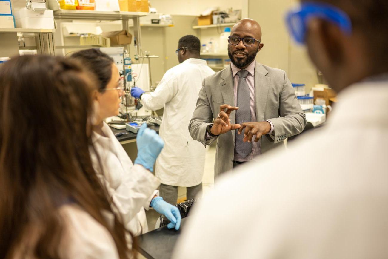 Professor Damilola Daramola speaks with students in his research lab