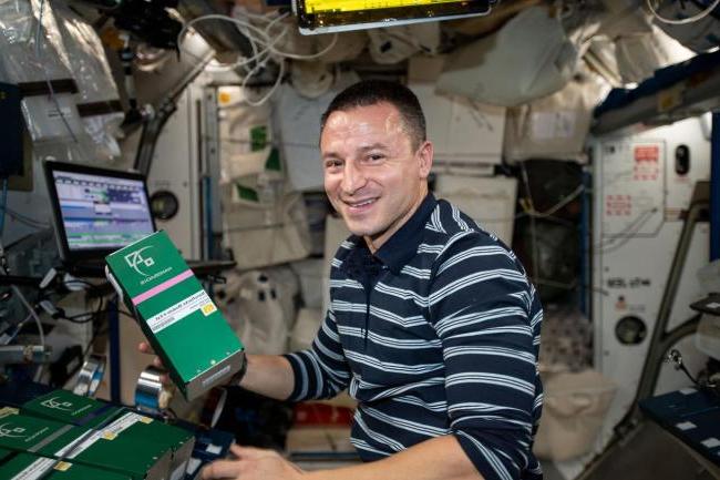 NASA宇航员Drew Morgan在停用和/或摇动指定的混合管时的照片